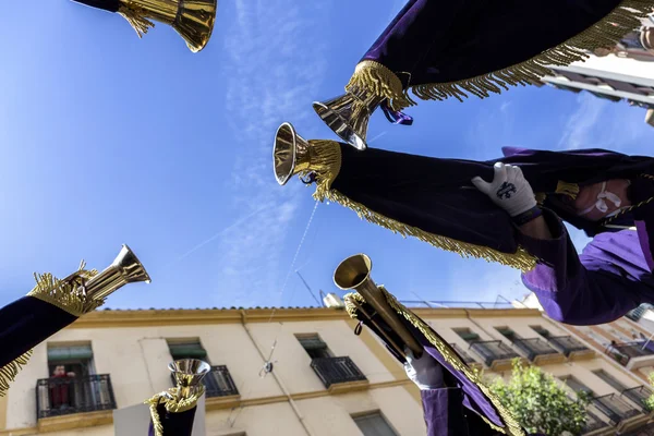 Penitents playing trumpets during Holy week in the good Friday procession, take in Linares, Jaen province, Spain