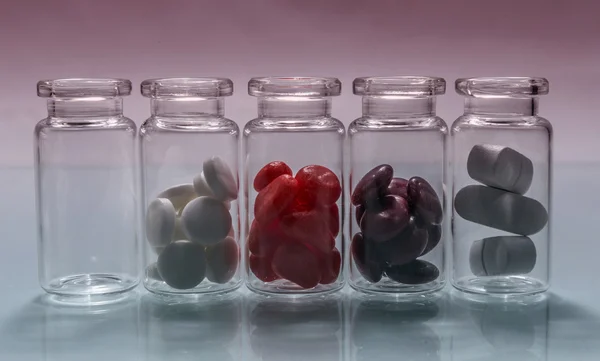 Small bottles of diferent pills lined up