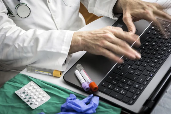 Hands of doctor writing fast on laptop