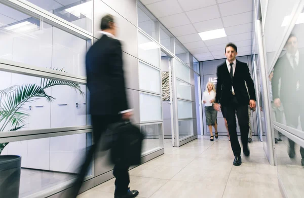Business office daily life. Blurred people walking in an office
