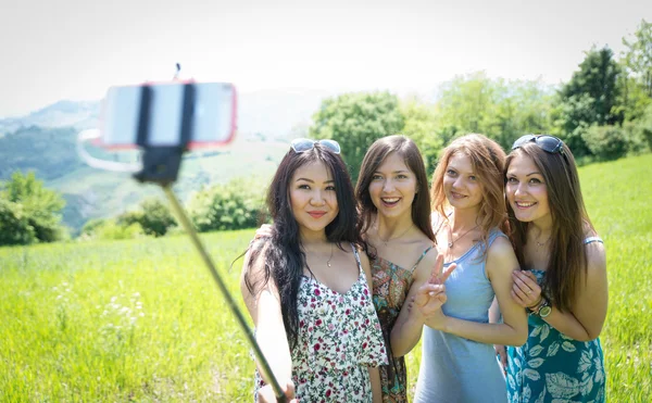 Group of girls making selfie with selfie stick