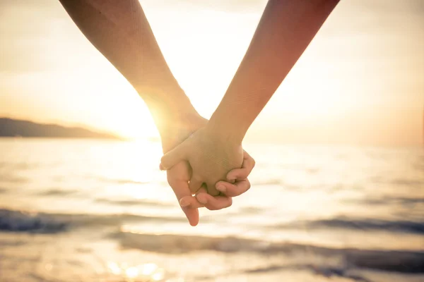 Couple holding hands at sunset