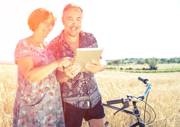 Senior couple looking something on the tablet.