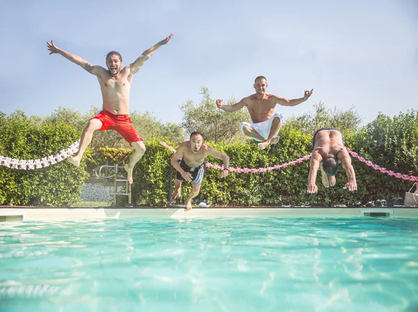 Friends jumping in a swimming pool