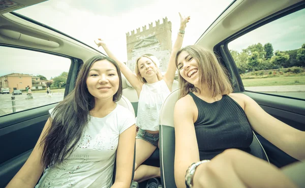 Three girls driving around with a city car