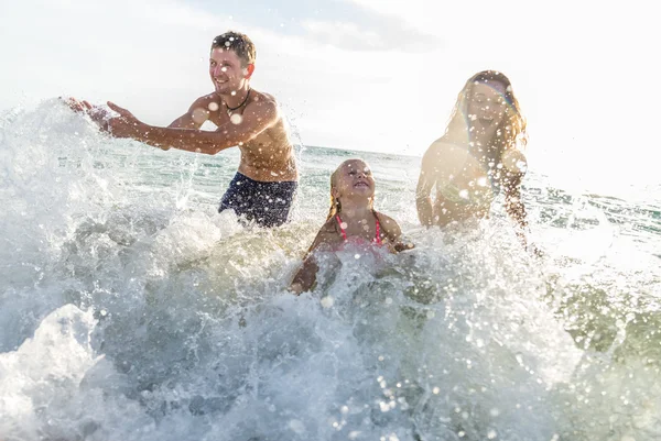 Happy family playing in the ocean