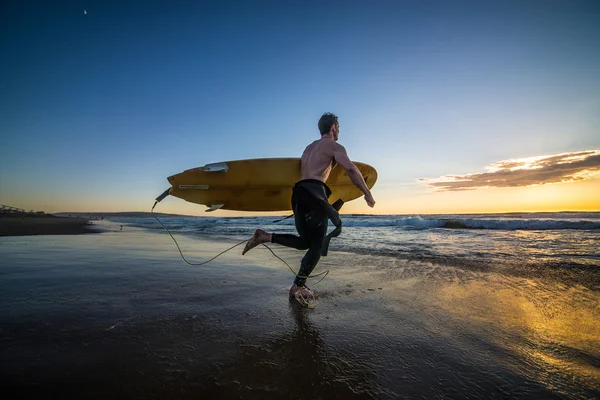 Surfer running on the beach