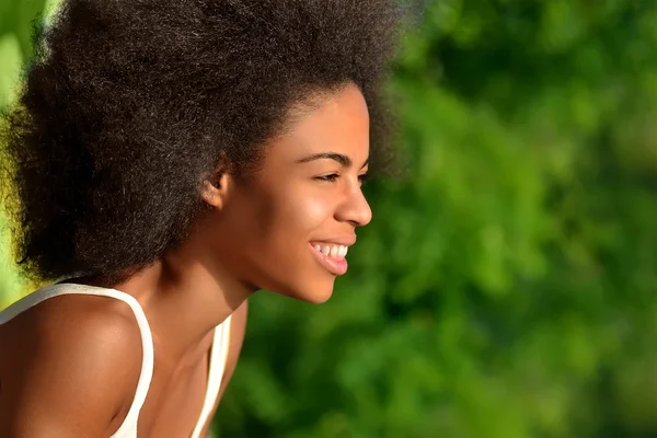 Young happy and pretty afro woman closeup portrait on natural background