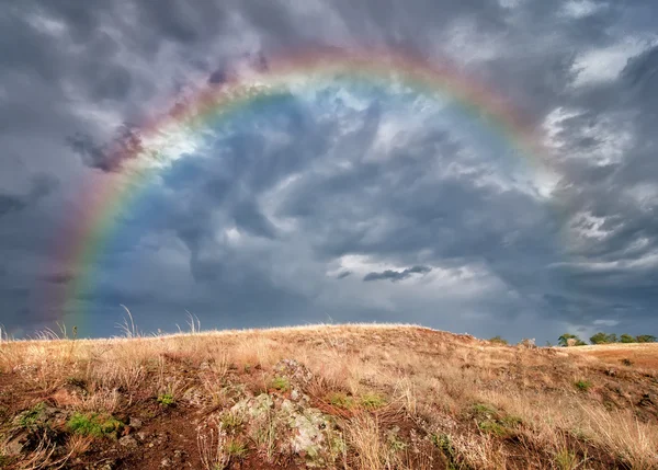Dramatic storm cloud and rainbow over the field, natural backgro