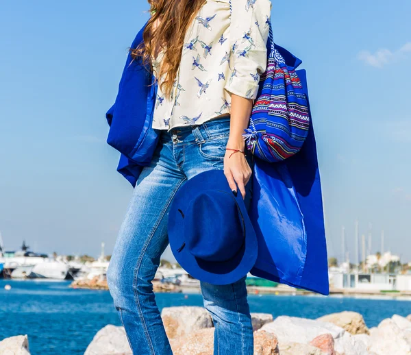 Outdoor fashion portrait of beautiful model, wearing warm stylish outfit with coat and sneakers in city yacht club. Autumn street style.