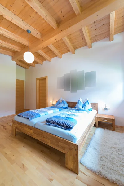 Vertical shot of wooden bed in bedroom at timber house
