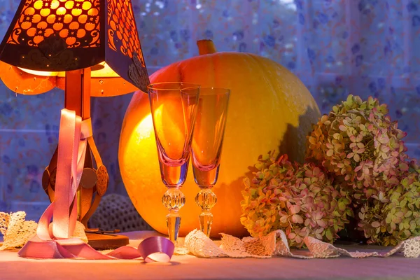 Pumpkin, glass cups, hydrangea, fonr and lamp warm light. Romant