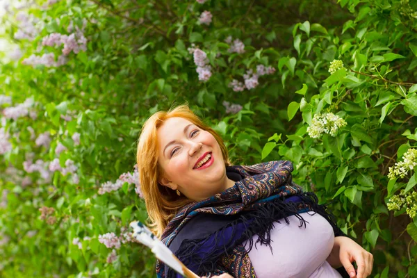 Young woman in motion on the background of blooming lilacs, spar