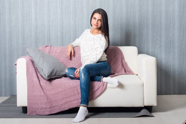 Relaxing at home, comfort. cute young woman smiling, relaxing  on white couch, sofa  at home
