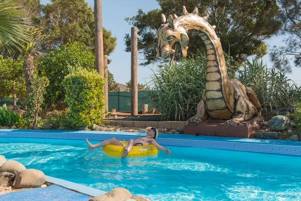 A man riding on a circle in the water park swimming pool