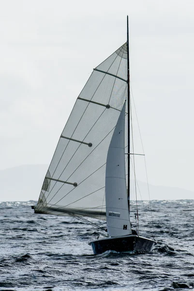 Small Sailboat with Full Sails in the Wind