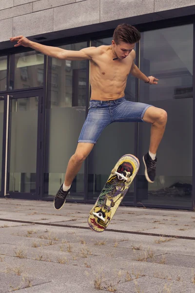 Young blonde guy jumping on skateboard in casual outfit in the u