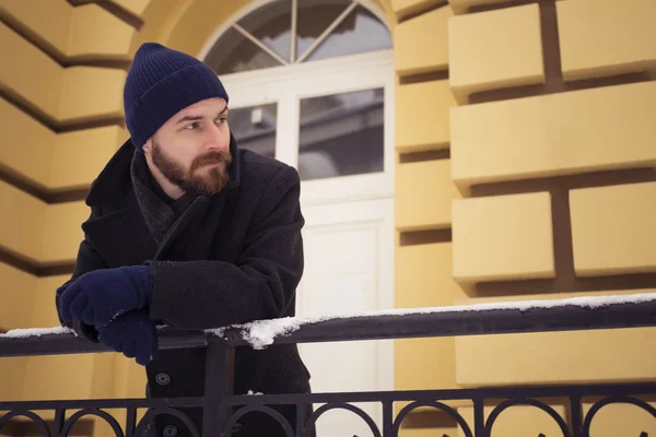 Handsome bearded man in jacket outdoors. Snow cold weather