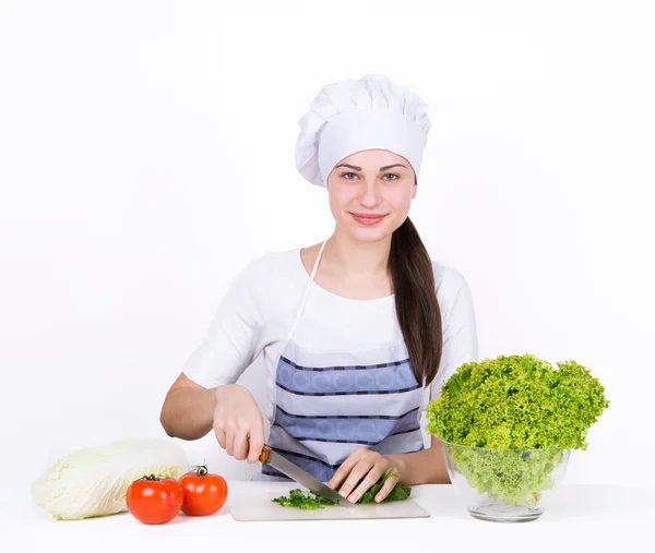 Smiling girl chef cuts fresh salad