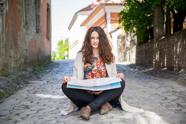 Tourist smiling girl sitting on the ground