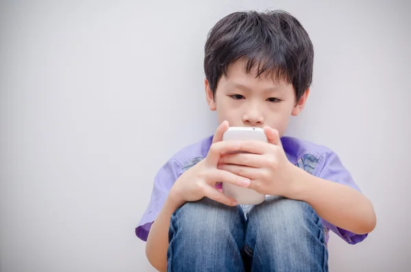 Boy plays game on smart phone