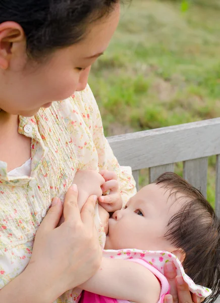 Asian mom breast feeding her baby girl