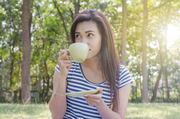 Woman drinking coffee in park