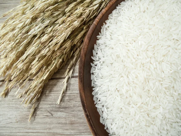 White rice on the wooden plate and rice plant