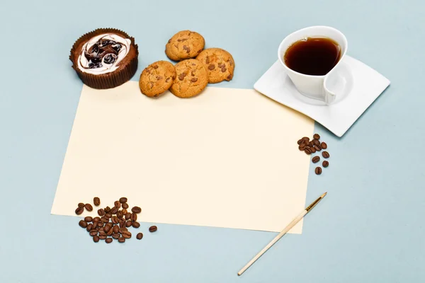 Mock-up template with white blank empty A4 sheet and cup of coffee on a color paper texture. Cake, coffee beans and biscuits on a table. Creative morning. Designer\'s breakfast.
