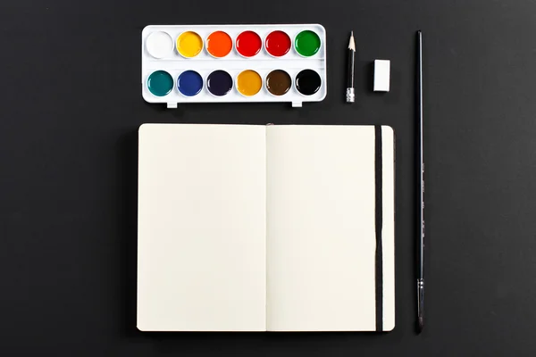 Open blank notepad with empty white pages laying with water-colo