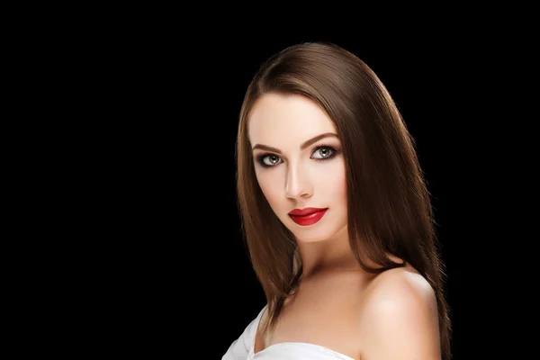 Young beautiful brunette woman with makeup and red lips in white shirt on black background