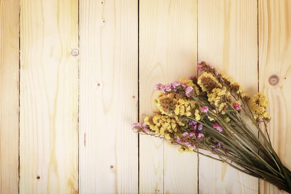 Bouquet of dried flowers on wooden planks background