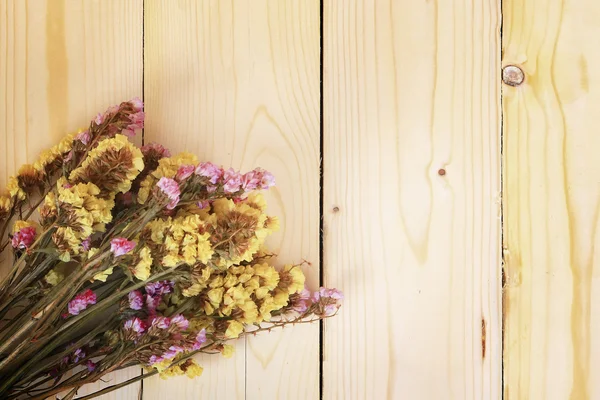 Bouquet of dried flowers on wooden planks background