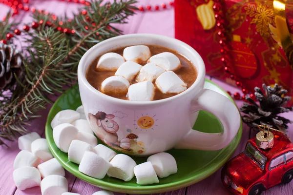 A cup of cocoa with marshmallows on pink background