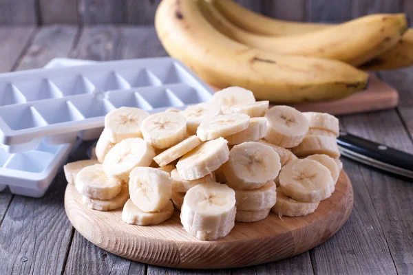 Bananas and banana slices on a wooden board