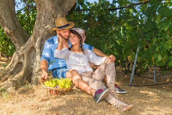 Happy young farmers enjoying a work break in the vineyard.