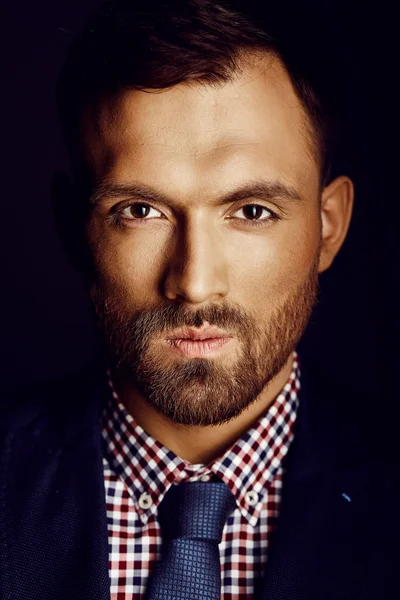 Beautiful man in shirt posing on a background of gray wall