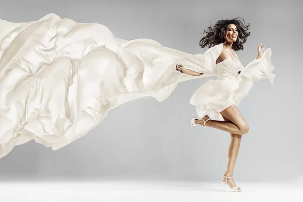 Woman in waving dress with flying fabric