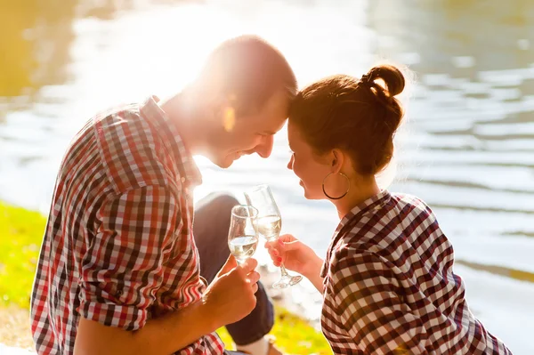 Man and woman clanging wine glasses with champagne