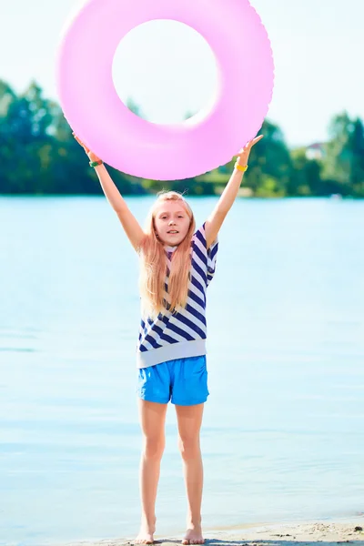 Happy girl play swim ring at the beach