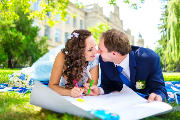 Happy man and woman colouring or drawing hearts at the garden. Love concept