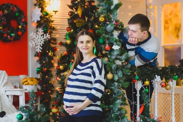 Happy pregnant couple playing fun game. Christmas concept happy pregnancy.