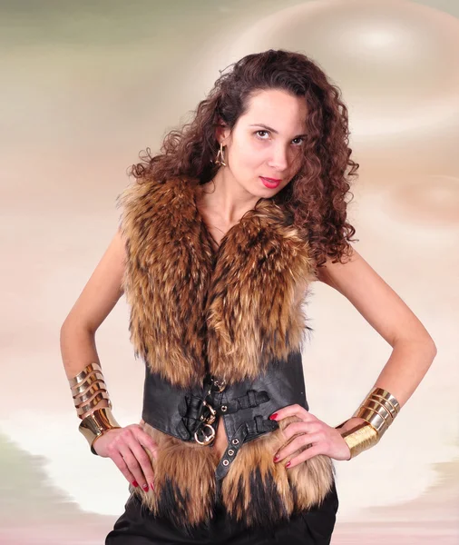 Young girl with curly hair in a fur coat on an abstract background