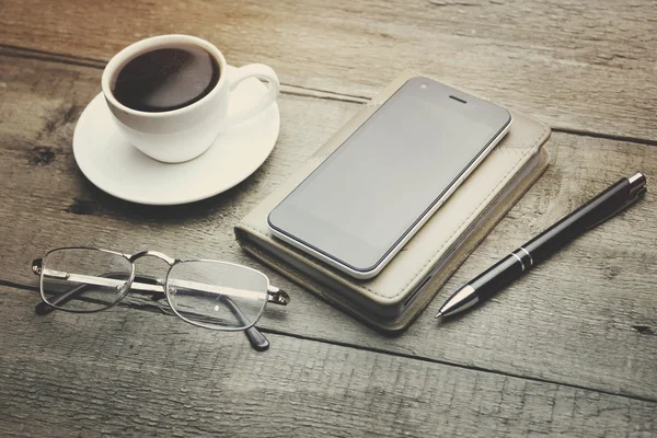 Coffee, phone, notebook, pen and glass