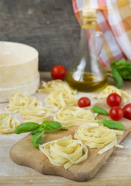 Fresh homemade pasta machine pasta, basil,. tomatoes on a wooden