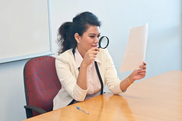 Business woman examine contract details by magnifier