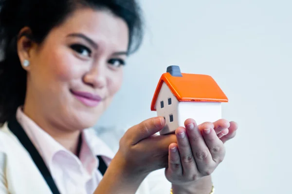 Woman hold a house model on white background