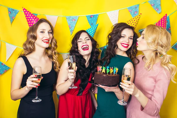 Portrait of joyful friends toasting and looking at camera at birthday party. Attractive friends celebrating a birthday. Smiling girls with glasses of champagne