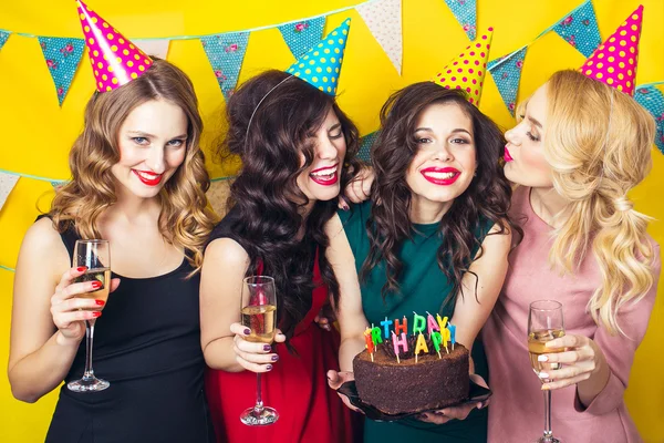 Portrait of joyful friends toasting and looking at camera at birthday party. Attractive friends celebrating a birthday. Smiling girls with glasses of champagne