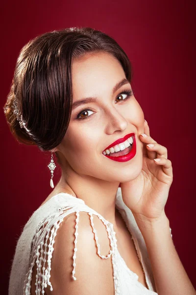 Portrait of the beautiful young girl in an image of the bride with ornament in hair.Beautiful young model with red lips.Woman with Perfect Makeup. Red Lips . Glamorous Woman.